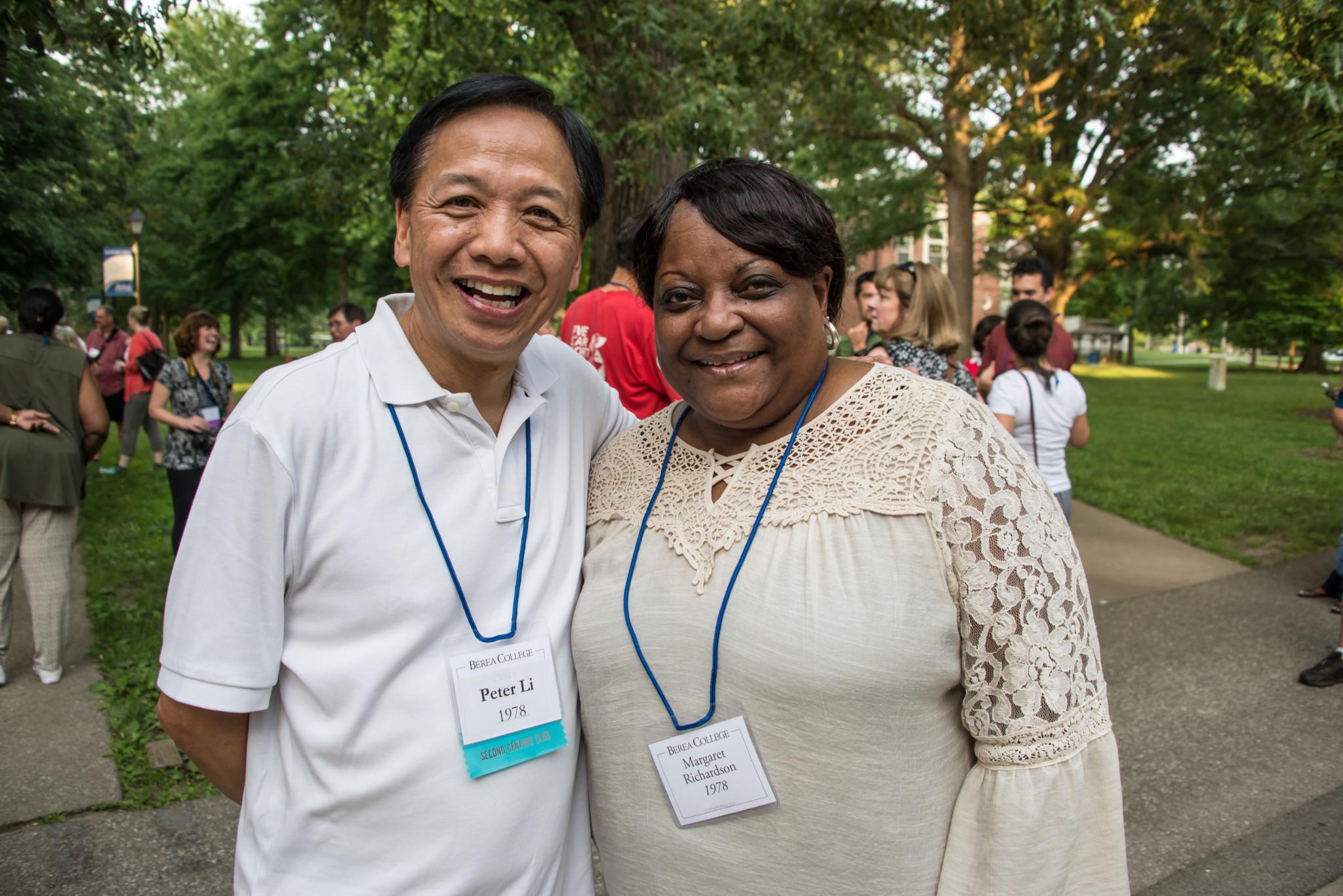 A smiling man stands near a smiling woman and pose together.