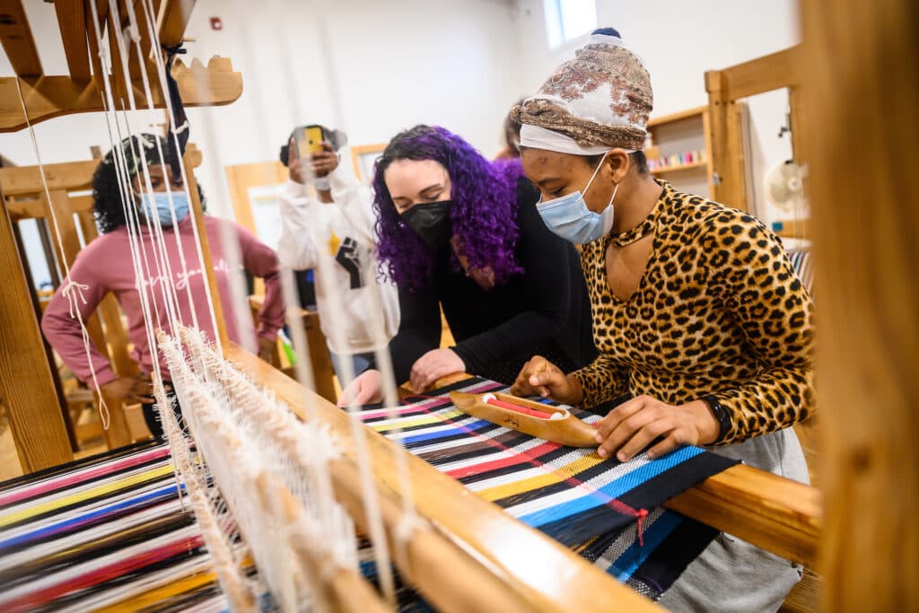 Head of weaving Erin Miller guiding students through the process.