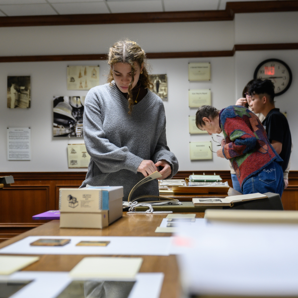 Three students view documents retrieved from the Archives in Hutchins Library.