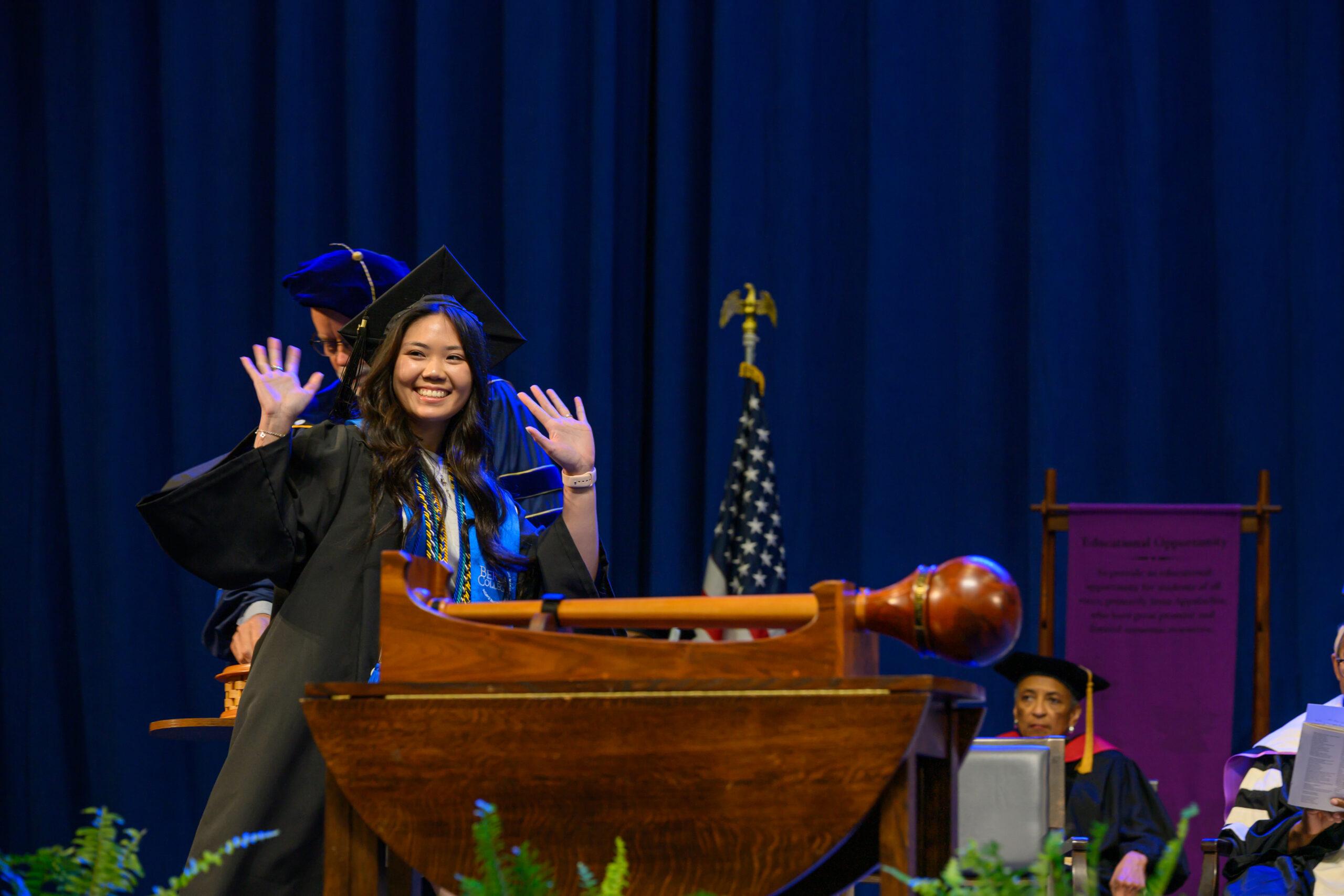 A female student dressed in Berea regalia walks across the commencement stage in May 2026.
